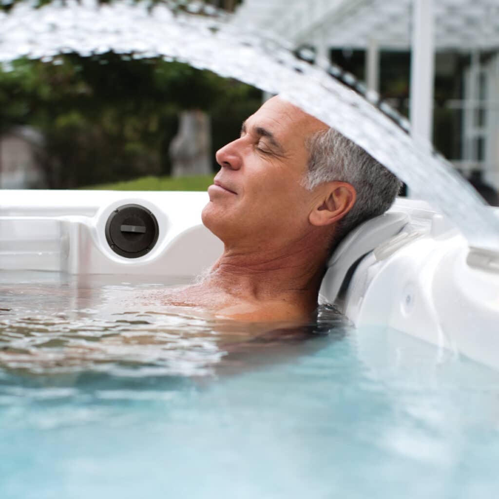 man enjoying hydrotherapy in hot tub