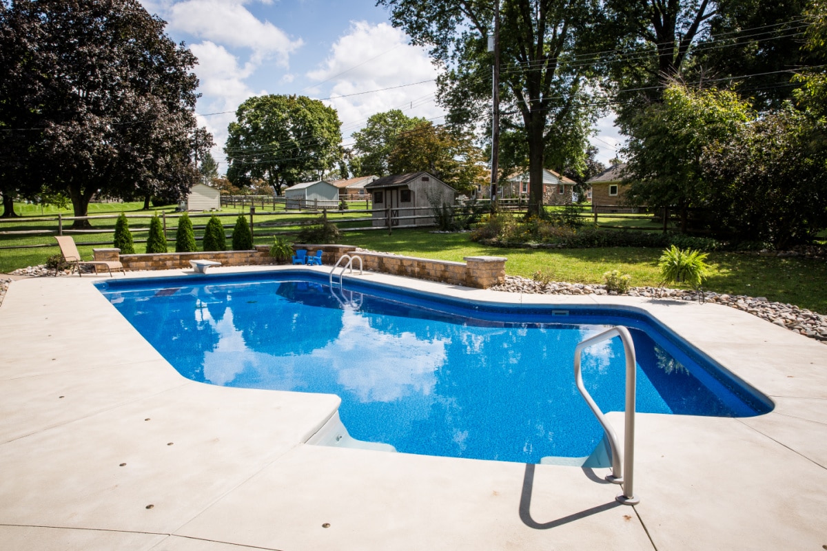 A stunning inground pool in a beautiful residential backyard.